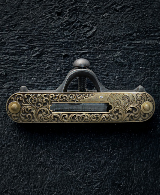 Hand engraved gold tone vintage leveler, sitting on a black textured background.