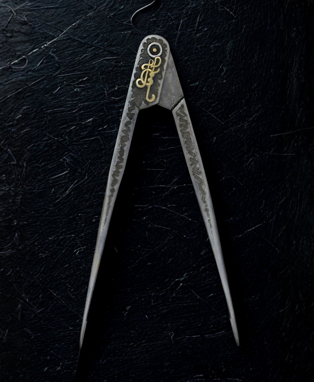 Metal compass on a textured black background