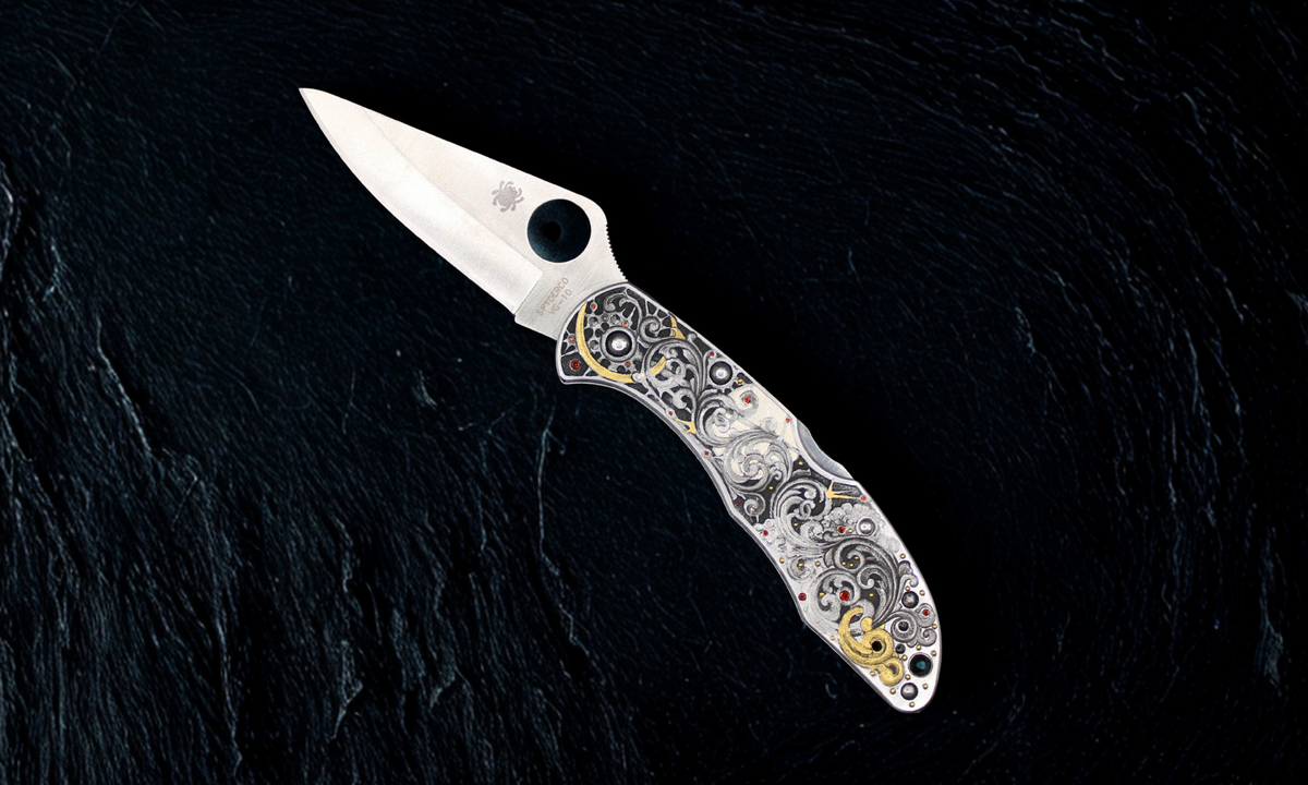 Decorative folding knife with additional tools on a dark textured background