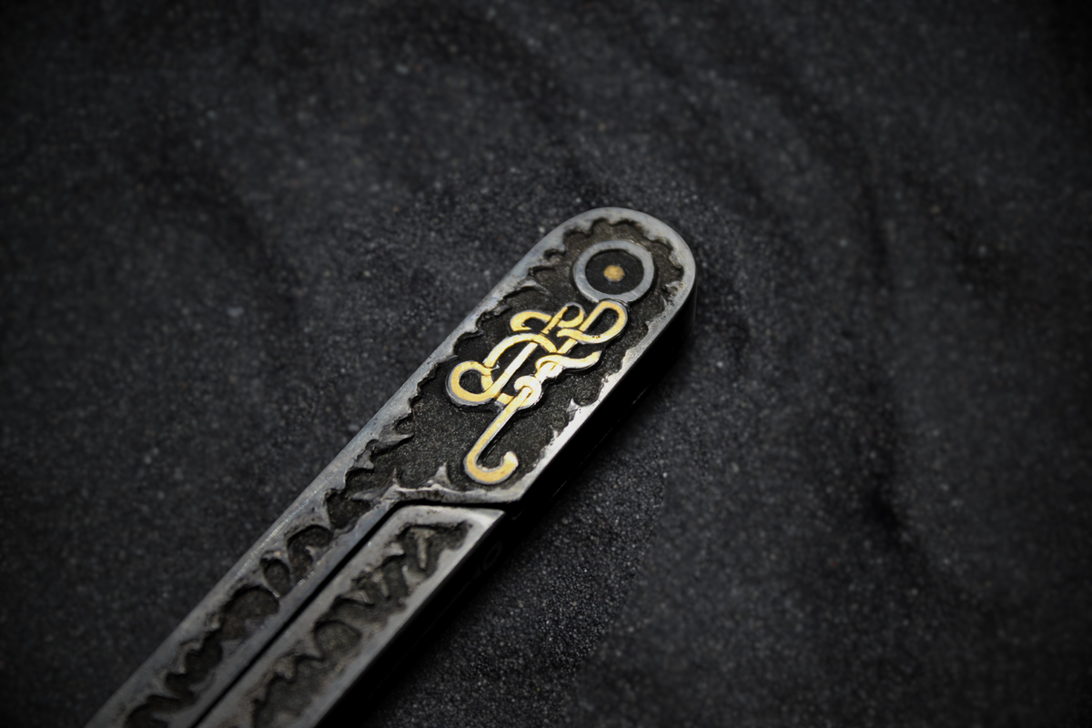 Decorative metal object with intricate designs on a dark background