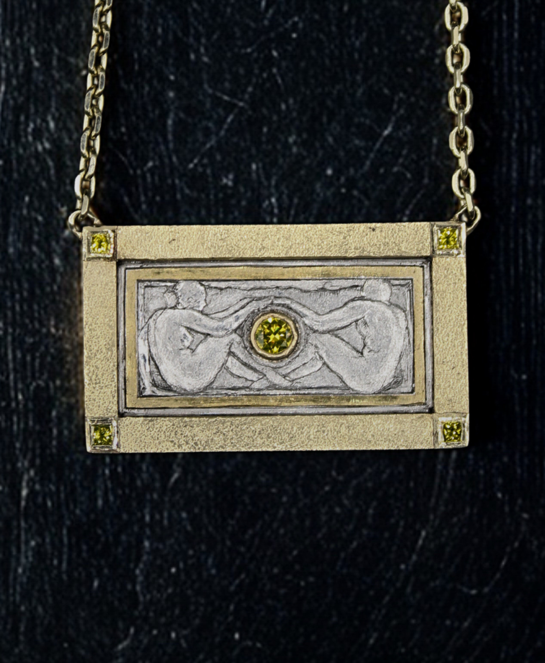 Gold pendant with a central gemstone on a dark background