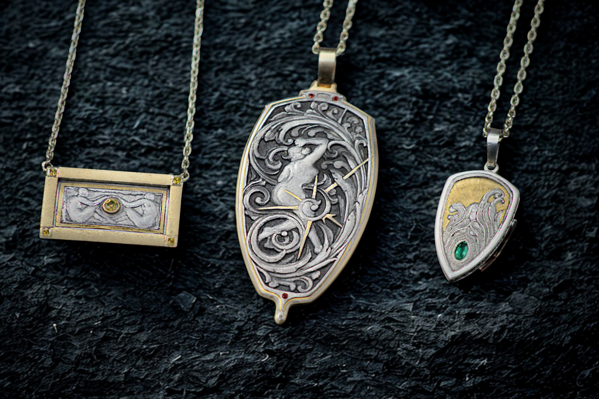 Three ornate necklaces with intricate designs on a dark textured background